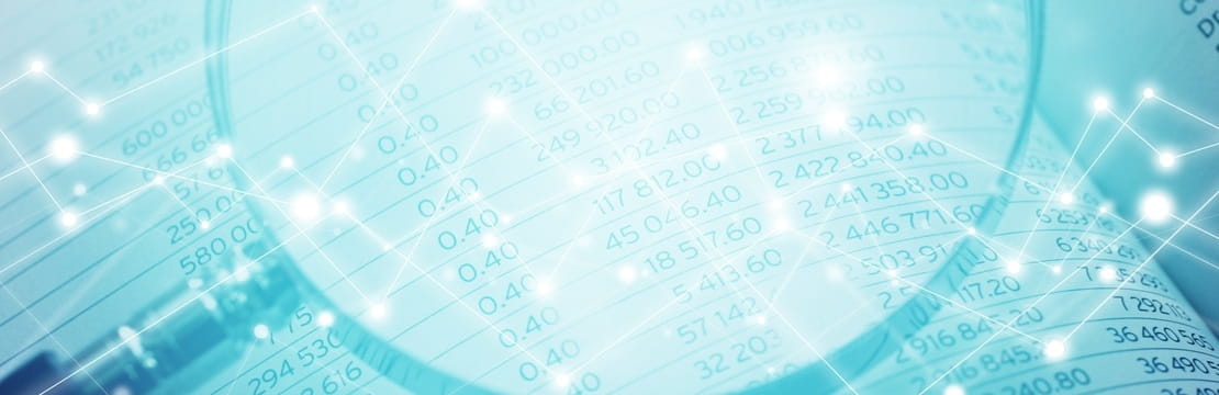 A magnifying glass highlighting rows of numerical data on a spreadsheet