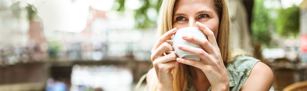 A women drinking from a cup in a shop