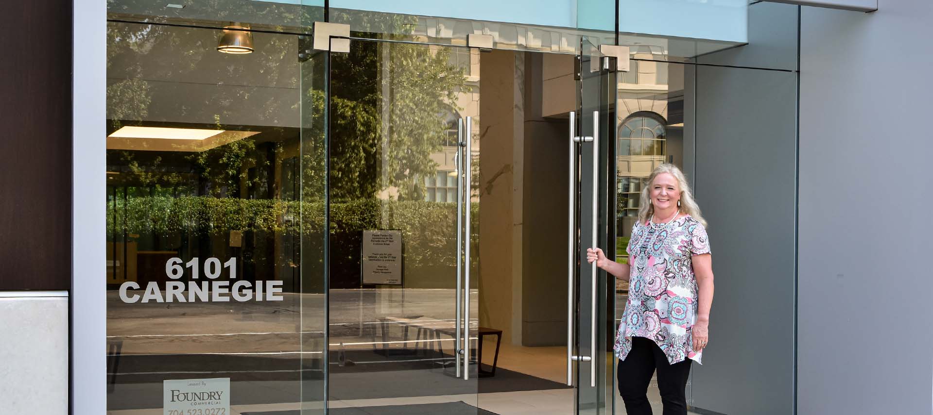 Leslie holding a door to the office